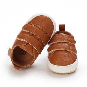 Close-up of brown faux leather baby walking shoes with soft soles and velcro straps