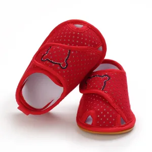Detailed view of red polka dot baby sandals with soft rubber sole and bear patch