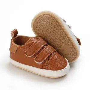 Detail view of brown leather baby soft sole shoes with non-slip dots and velcro straps.