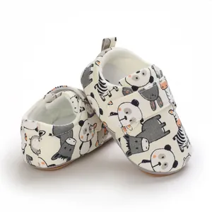 Detailed view of baby walking shoes with cute cartoon animal prints and soft soles.