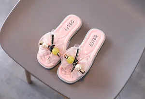 Gros plan détaillé des fleurs en dentelle et des perles sur les sandales roses pour filles