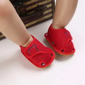 Detail of red baby sandals with bear embroidery and mesh fabric for toddlers.