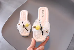Gros plan de chaussons roses pour filles avec fleur en résille et décor de perles