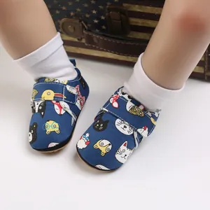 Detail of baby soft sole shoes with colorful cartoon animal prints and Velcro strap.