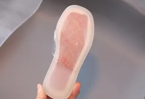 Vue détaillée de la semelle transparente souple et de la texture antidérapante des sandales