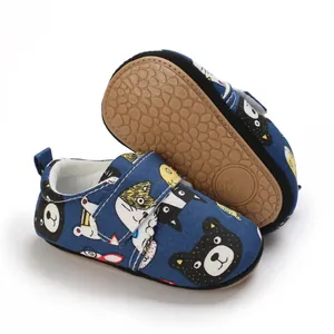 Close-up of the anti-slip soft rubber sole and cartoon print on blue baby walking shoes.