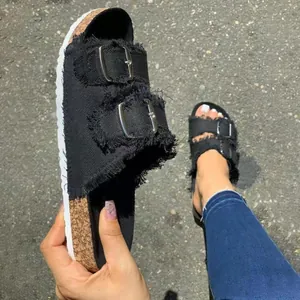 Dettaglio dei sandali in denim nero da donna con doppia fibbia e suola in sughero