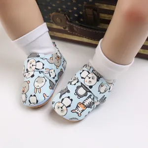 Detail view of light blue baby walking shoes featuring cute cartoon animal patterns