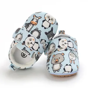 Detail view of light blue baby walking shoes with cute animal prints and velcro strap