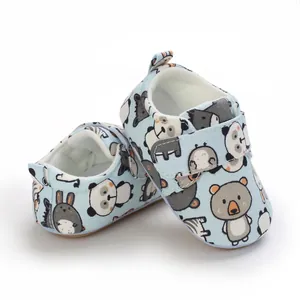 Detail showing soft sole infant walker shoes with cute cartoon animal prints and velcro