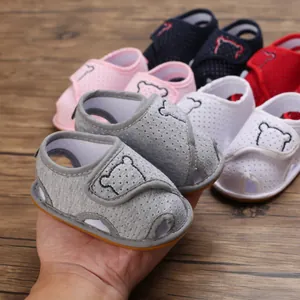 Close-up of soft-soled baby cartoon sandals with breathable mesh and bear embroidery.