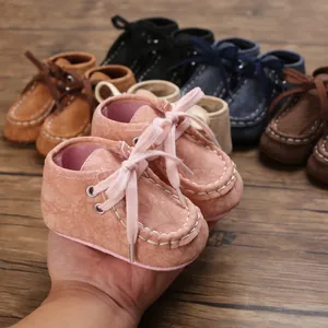 Nahaufnahme von weichen rosa Baby-Lauflernschuhen mit weißen Ziernähten