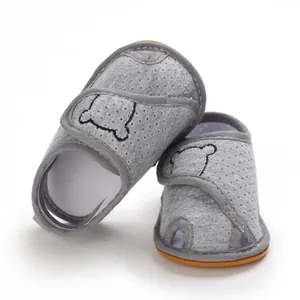 Close-up of grey mesh baby sandals with cute bear embroidery and soft rubber sole