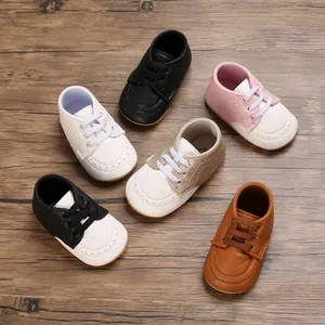 Various colors of soft sole anti-slip baby walking shoes on wood background
