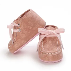 Detailaufnahme von rosa Baby-Lauflernschuhen mit Textur und hübschen Schleifen