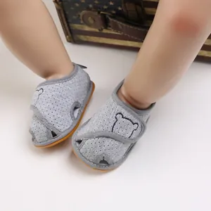 Close-up of grey breathable baby sandals with cartoon bear embroidery and soft rubber sole.