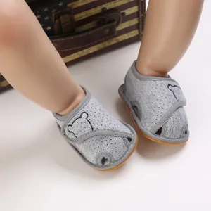 Close-up view of grey baby walker sandals with cartoon bear pattern and soft rubber sole