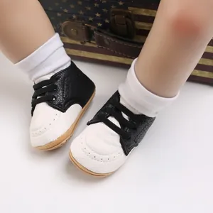 Classic black and white baby walking shoes with soft rubber soles and white socks