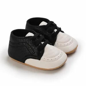 Close-up detail of black and white infant walking shoes with soft anti-slip rubber soles