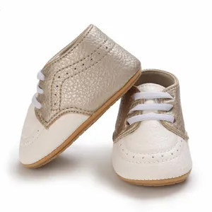Detailed view of white and gold soft-sole baby pre-walker shoes with white laces