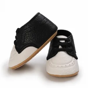Close-up of black and white baby toddler shoes with soft rubber non-slip soles.