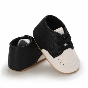 Detail of black and white faux leather baby walker shoes with soft rubber sole