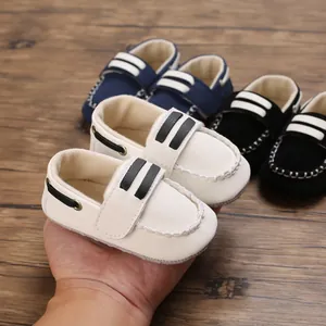 Detailansicht eines weichen weißen Babyschuhs in der Hand mit verschiedenen Farboptionen