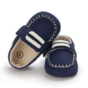 Vista detallada de zapatos de bebé azul marino con costuras blancas y suela blanda