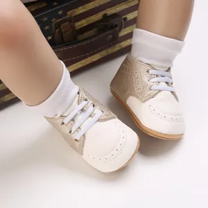 Close-up of gold and white infant pre-walker shoes with soft soles and white laces