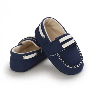 Zapatos de bebé azul marino con suela blanda y elegantes detalles de costuras blancas.
