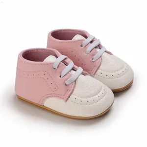 Close-up of pink and white soft-soled baby walking shoes with anti-slip rubber bottom.