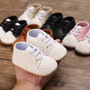 Detailed view of white soft-soled non-slip baby walking shoes held in hand with color options