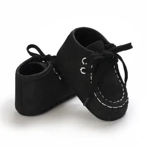 Makro-Detail von schwarzen Baby-Lauflernschuhen mit weißen Kontrastnähten