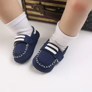 Primer plano de zapatos para caminar de bebé azul marino con suela blanda y costuras