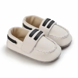 Vista detallada de zapatos de gateo para bebé en color crema con suela blanda y negro.