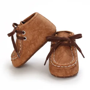 Detailansicht der braunen Lauflernschuhe für Babys mit weißen Nähten und Schnürdesign