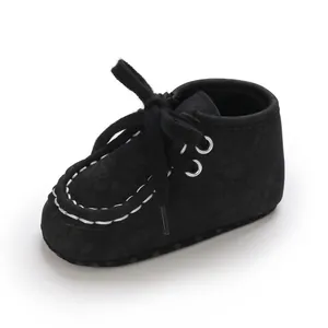 Detailansicht der schwarzen Baby-Laufschuhe mit Schnürsenkeln und weißen Nähten