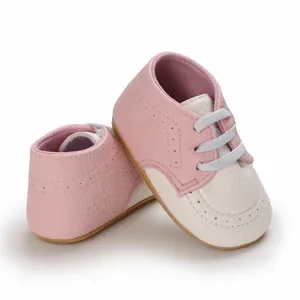 Close-up of pink and white soft sole baby walking shoes with anti-slip design