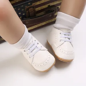 Detailed view of white baby walking shoes with soft non-slip soles and elastic laces