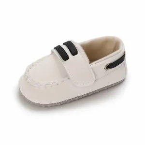 Detalle de zapato blanco para bebé con correas negras decorativas y suela blanda