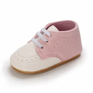 Macro view of pink and white soft leather baby walking shoe with non-slip sole