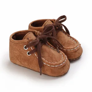Nahaufnahme von braunen Baby-Lauflernschuhen mit weißen Nähten und strukturierter Kunstleder-Optik.