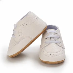 Macro detail of white faux leather infant walking shoes with soft non-slip soles