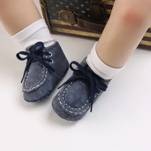 Nahaufnahme von blauen, melierten Babyschuhen mit weicher Sohle und weißen Socken