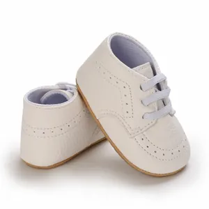 Close-up view of white leather infant pre-walker shoes featuring anti-slip rubber soles