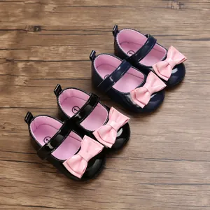 Detailansicht von Baby-Lauflernschuhen in Schwarz und Marine mit rosa Schleifen