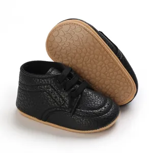 Macro view of black infant walking shoes featuring soft non-slip rubber pebble soles