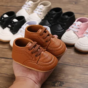 Macro view of brown faux leather baby walking shoes with soft non-slip rubber soles