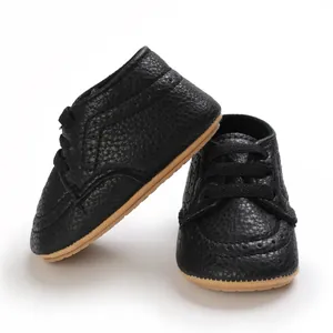 Detailed view of black textured faux leather baby walking shoes with non-slip soft soles