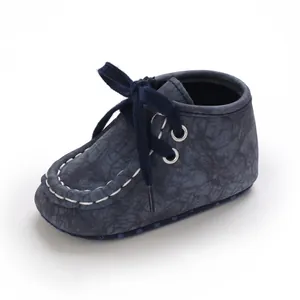 Detailansicht dunkelblauer Babyschuhe mit Riss-Textur und weichen Schnürsenkeln.